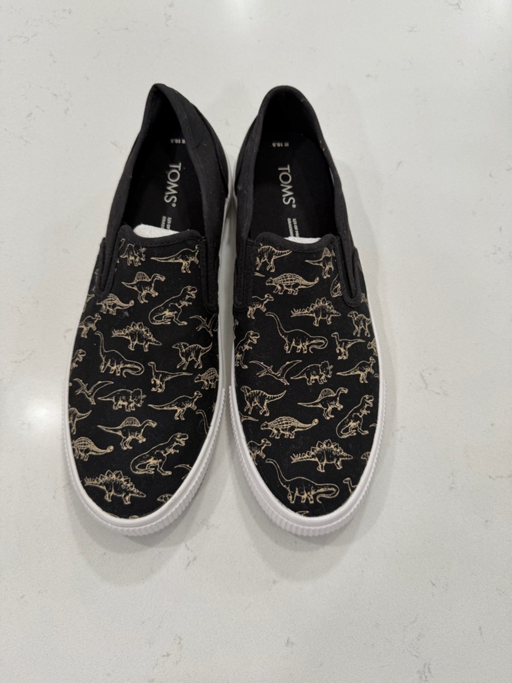 TOMS Black Slip-On Sneakers with Gold Dinosaur Outline Print
